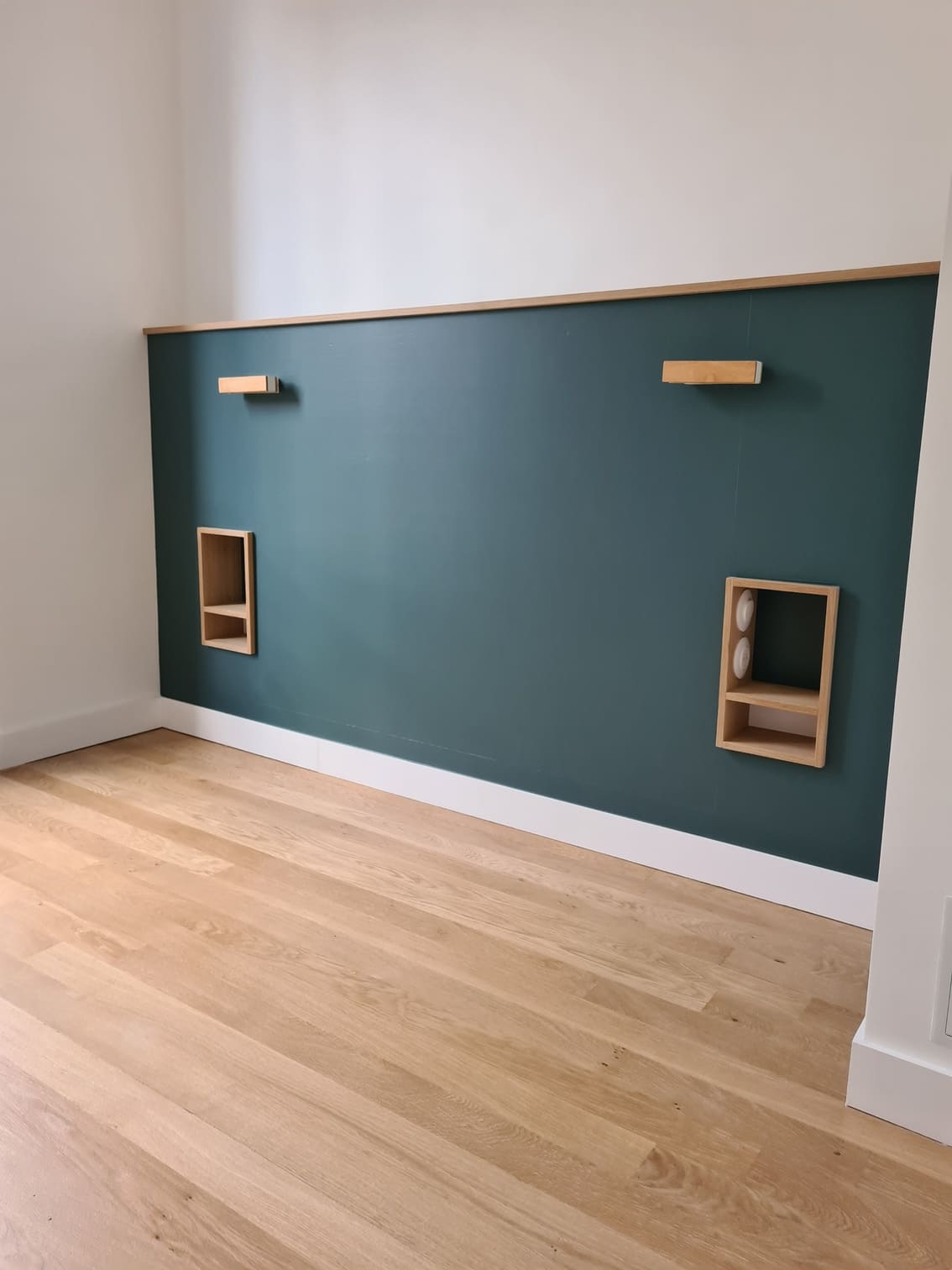 Mur de chambre peint en vert sapin avec niches en chêne et parquet neuf, réalisé par JPM Rénov